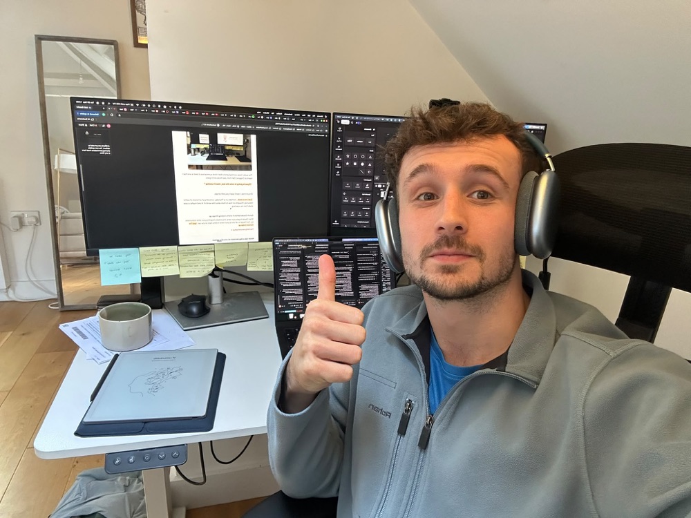 Me at my desk, headphones on, giving a thumbs up